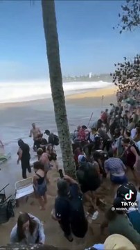 Une grosse vague surprend les spectateur de cette compétition de surf
