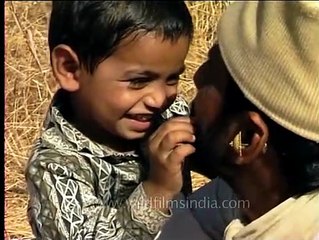 Maldhari man plays with his child