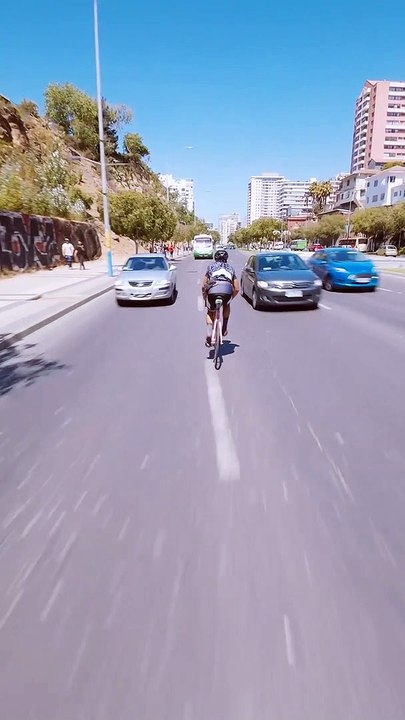 Deux cyclistes s'amusent à rouler en sens inverse sur un grand boulevard
