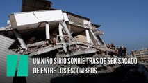 Un niño sirio sonríe tras de ser sacado de entre los escombros