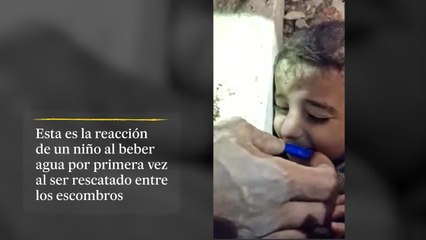 Un niño bebe agua de un tapón de una botella antes de sacarlo de los escombros tras el terremoto de Turquía