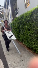 Man Carries Around Street Sign