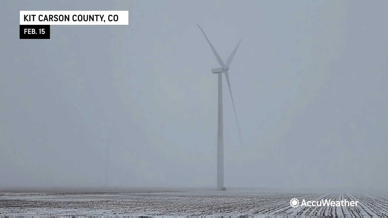 Wind turbines spin in the midst of blowing snow