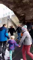 People dancing under Magazine Gate on a rainy day in Derry