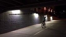 Guy rides bike down hill into parking lot and hits his head while hanging on height bar