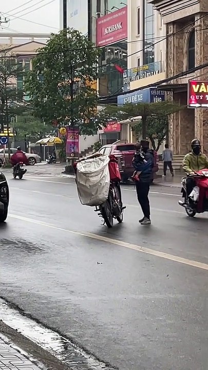 Ông bố shipper vừa bế con nhỏ vừa lái xe giữa trời mưa rét: Cũng vì cuộc sống mưu sinh