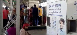 Passengers queue for water on platform