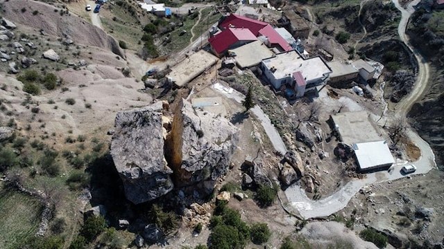 Depremlerin etkisiyle yerinden ayrılan kaya parçası eve çarpmış halde duruyor