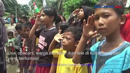 Semangat Peringati Hari Pancasila, Warga Asahan Upacara dan Tangkap Ikan di Jalan Rusak