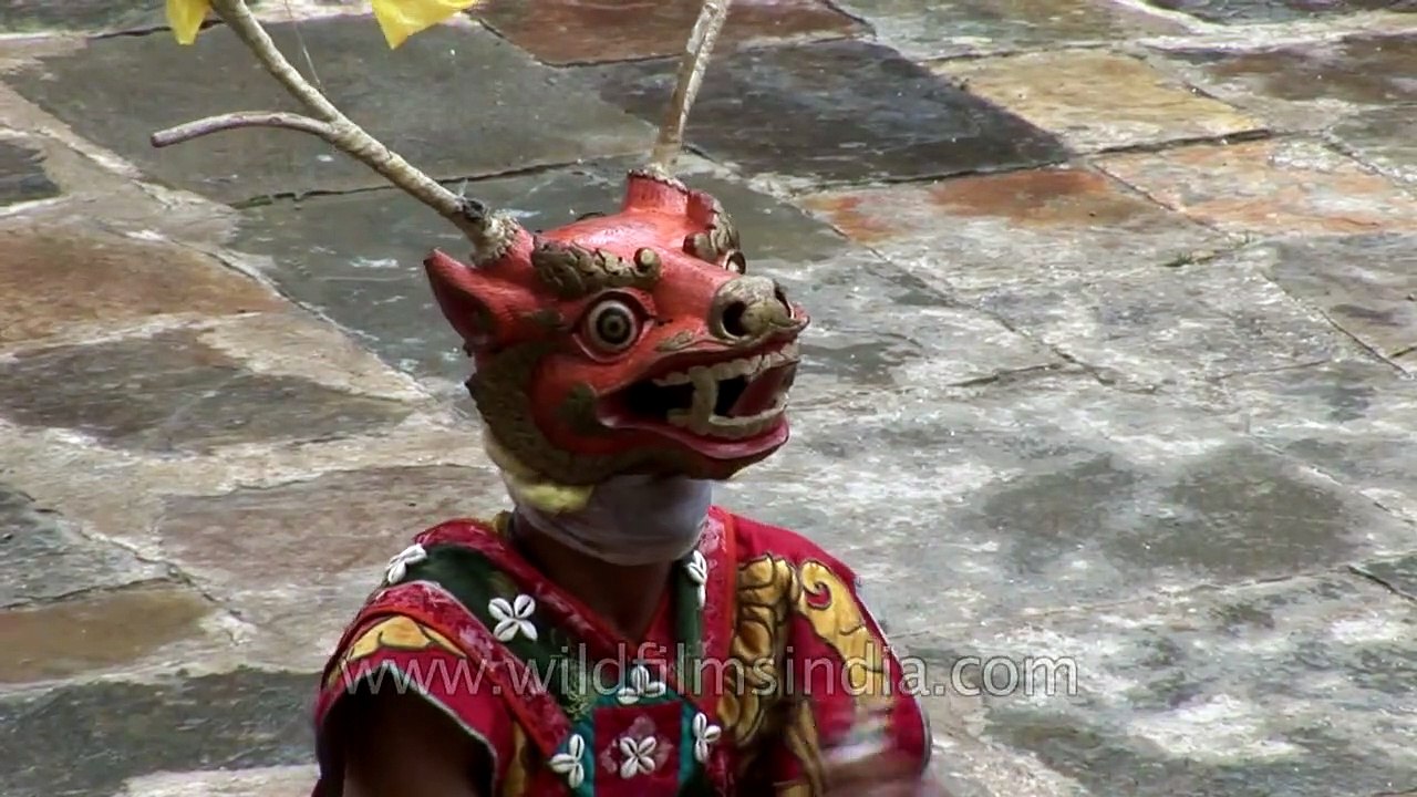 Animal masked dancer holding a stick performs the rituals of Cham dance in Bhutan