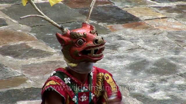 Animal masked dancer holding a stick performs the rituals of Cham dance in Bhutan