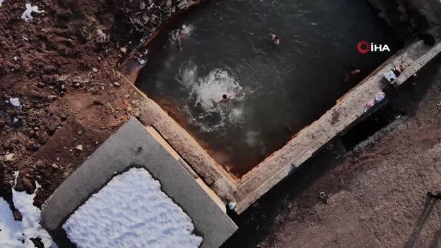 Etrafı karla kaplı doğal jakuzinin keyfini çıkarıyorlar