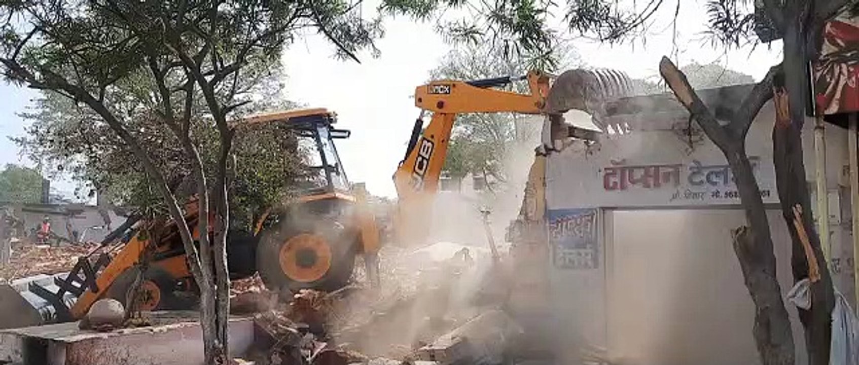 दुकानें हटाती जेसीबी