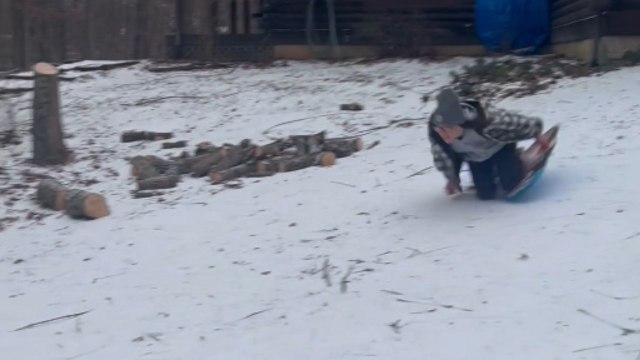 *Hilarious sledding fail* Girl falls over when trying to sled down the driveway