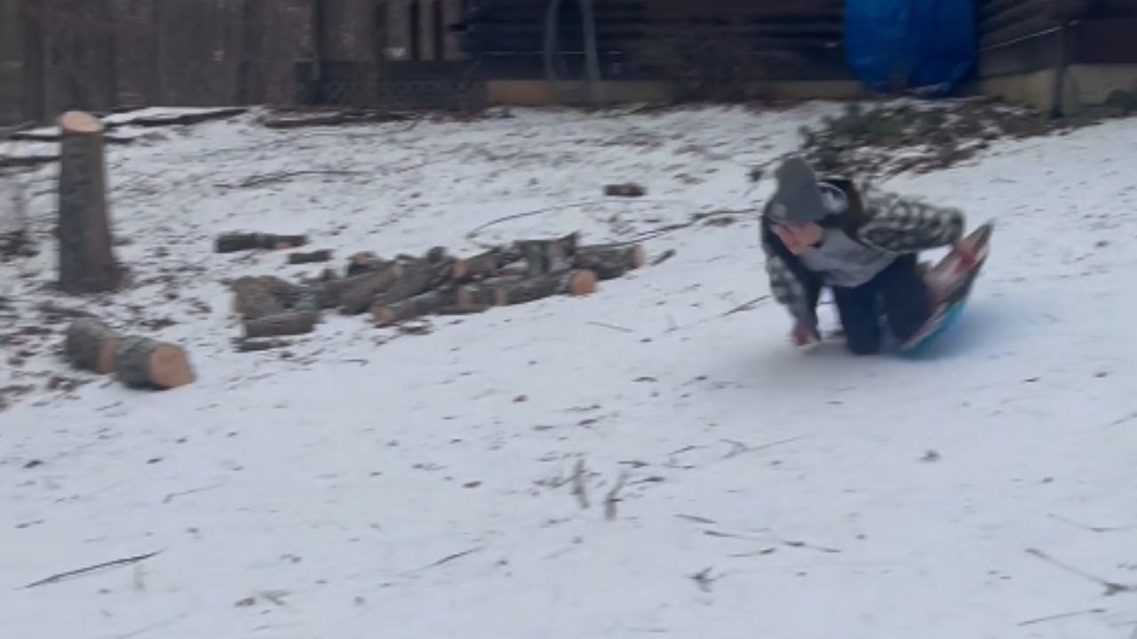 *Hilarious sledding fail* Girl falls over when trying to sled down the driveway