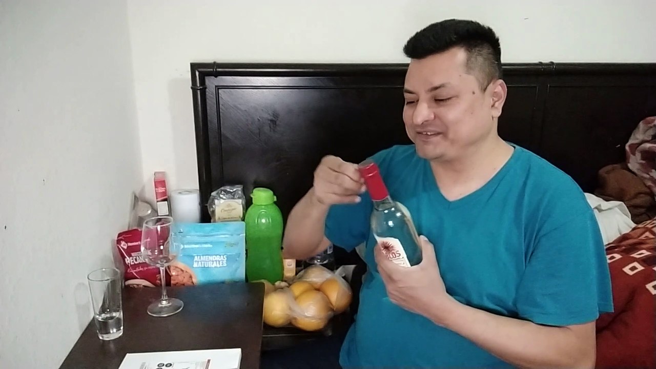 abriendo una botella de mezcal mil diablos de agave espadin celebrando el exito obtenido comiendo botana de chapulines enchilados