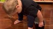 Persistent toddler struggles with using Barbie furniture for himself