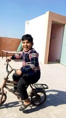 A boy riding a bicycle#short#boy#bicycle