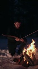 A man hunting with | Bow & Arrow | in the front of bonfire