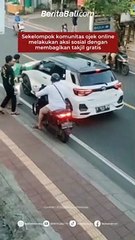 Sekelompok komunitas ojek online melakukan aksi sosial dengan membagikan takjil gratis kepada pengendara yang lewat Di Jalan Uluwatu