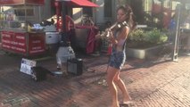 Beautiful girl playing violin and dancing on cute tune in the front of chicken & beef burger road side shop..