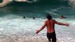 Des touristes s'amusent dans des vagues vraiment très très grosses