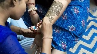 Woman applying henna on one hand to prepare for wedding ceremony, festival in India