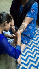 Woman applying henna on one hand to prepare for wedding ceremony, festival in India