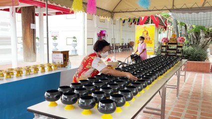 Make merit by dropping coins into the alms bowl Koh Kret Island Thailand