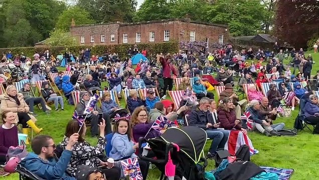 Crowds watch the Coronation of King Charles III at Powderham Castle