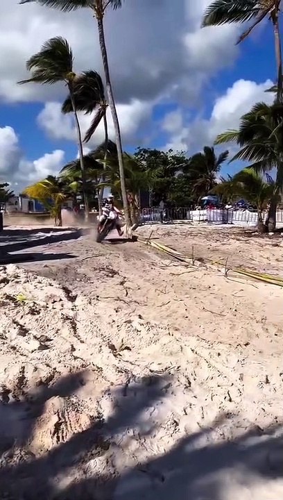 Un pilote de motocross rate son virage sur une plage