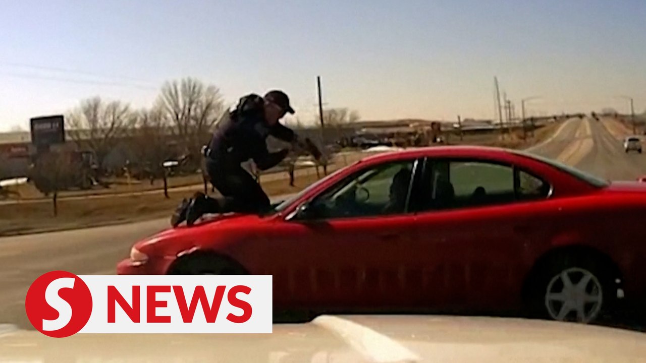 Iowa police officer clings to roof of escaping car