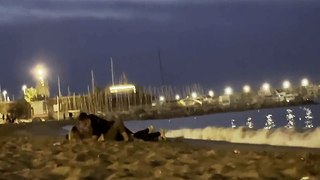 Une nana bourrée et son mec sur une plage