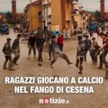 Dei ragazzi giocano a calcio nel fango: il simbolo di speranza per Cesena