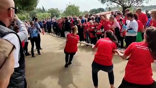 Une femme ne comprend pas bien les règles du jeu du tir à la corde