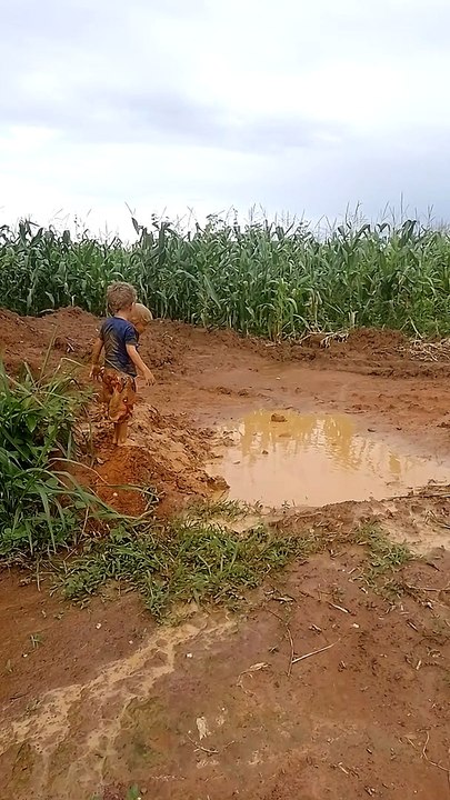 Boys Jump Into Mud Puddle