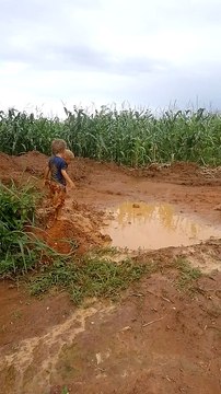 Boys Jump Into Mud Puddle