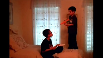 Jonathan plays the wii while Christopher shows off his toy gun