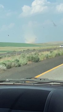 Car Drives Through Highway Crossing Dust Devil