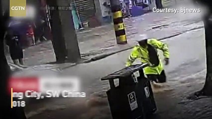 Chinese police officer carries over a dozen people across rapids