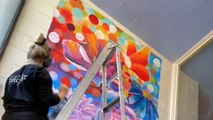 Artist paints a stunning and vibrant mural on the wall of a daycare center