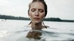 A Woman Submerging Full Body In Lake Water