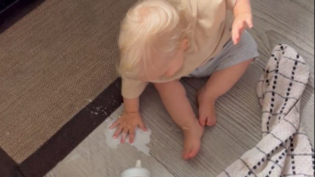 Jolly baby boy having fun at the expense of spilled milk
