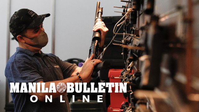 Gun enthusiasts scout for fire arms displayed at the 17th Tactical, Survival and Arms (TACS) Expo