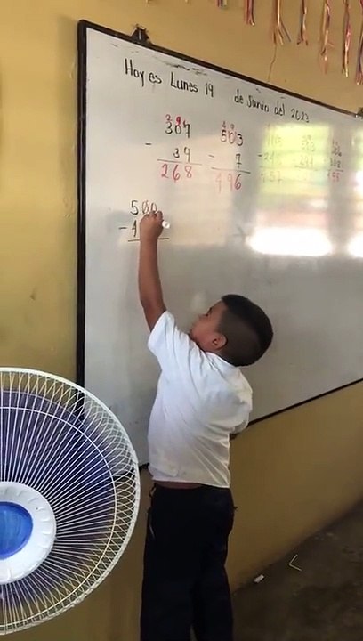 Niño hondureño muestra feliz cómo aprende matem...