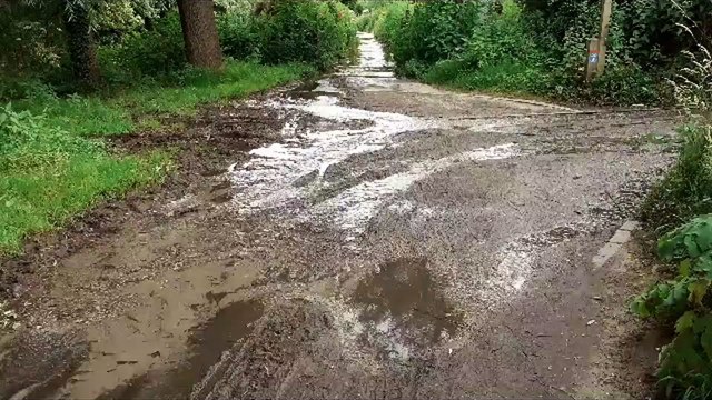 Runner splashing through flooding on the Medway River Towpath near Unicumes Lane, Fant
