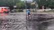 Cyclist and cars wade through submerged Berlin streets amid heavy rain and flooding