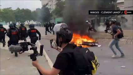 Fransa'da polis ve protestocuların çatısması arasında kalan bir kişi, hiçbir şey olmamış gibi sandviç yedi