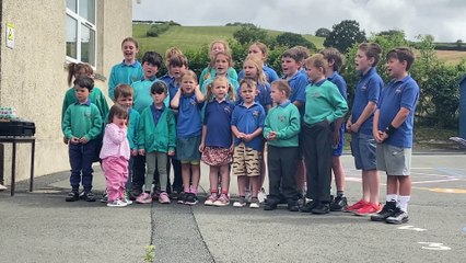 Pupils at Ysgol Llanfihangel-y-Creuddyn sing a song about their school as it celebrates its 185th anniversary