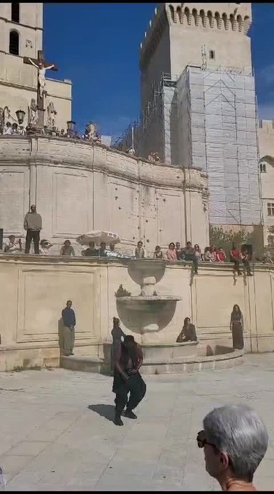 Entourée d'une armada de danseurs immobiles comme les statues alentour, Bintou Dembélé danse en solo devant le Palais des Papes